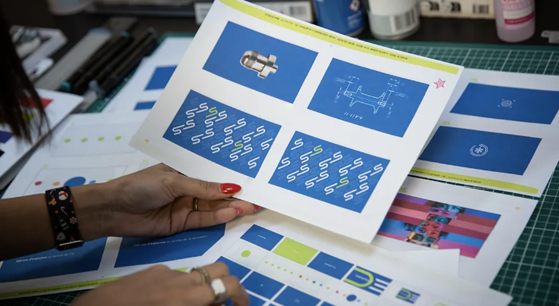 Feuilletage d'un catalogue imprimé sur une table de travail.