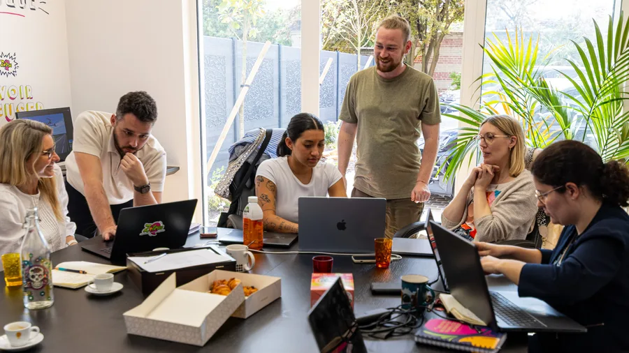 L’équipe Zetruc en atelier autour de la table avec un client, dans les locaux de l’agence.