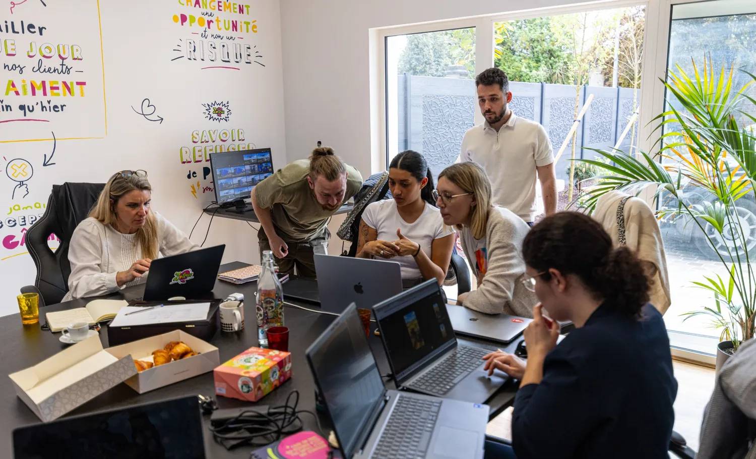 Les participants réunis autour de la table de formation, ordinateurs ouverts.