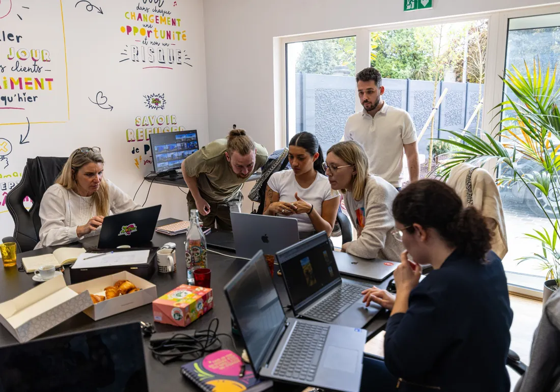 Les participants réunis autour de la table de formation, ordinateurs ouverts.