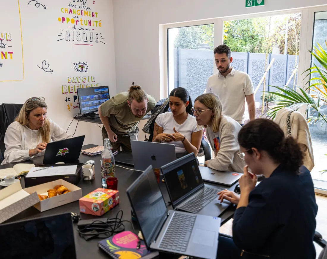 Les participants réunis autour de la table de formation, ordinateurs ouverts.