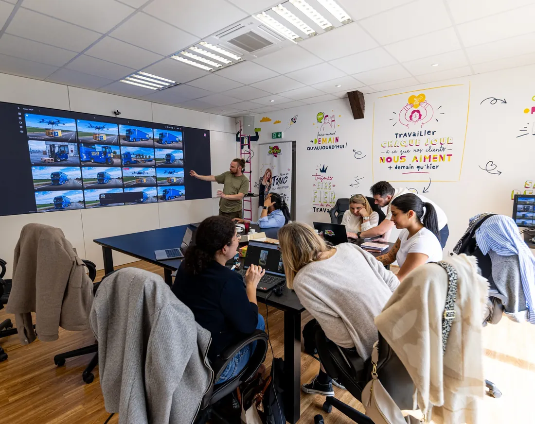 La salle de formation Zetruc, écran mural allumé, les participants installés face à l'écran.