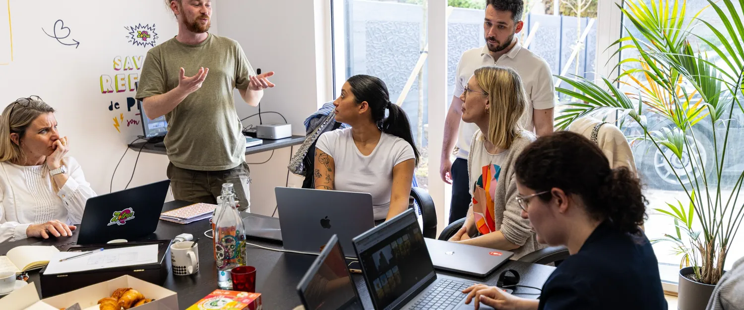 Le formateur explique devant le groupe, les participants travaillent sur leurs ordinateurs.