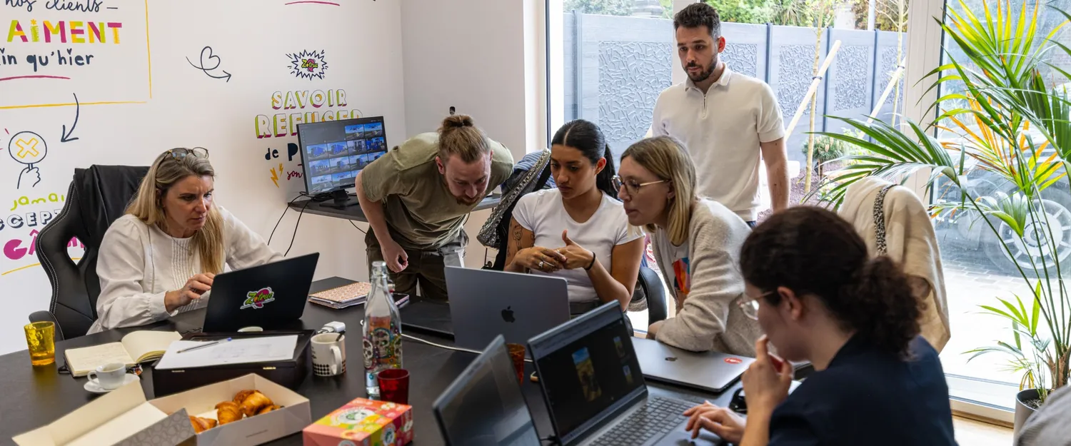 Les participants réunis autour de la table de formation, ordinateurs ouverts.