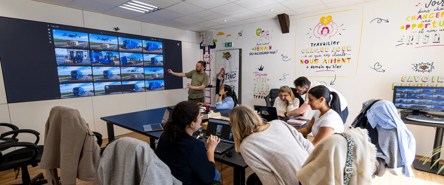 La salle de formation Zetruc, écran mural allumé, les participants installés face à l'écran.